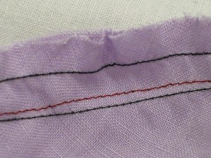 Black rows are ease stitching - red row is permanent seam line.  Easing causes the bias sections of the cap to stretch so seam line moves.