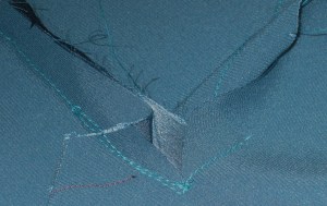 Inset corner where bodice is joined to the front/skirt section.  Pleat is caused by allowance for the pocket.