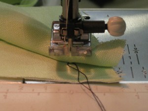 Thread is caught between stitches and can be pulled against needle before being tucked between the layers