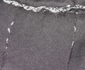 Top edge of underside of inverted pleat connected at neckline seam provides a stay for the pleat