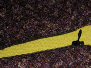 Facing side of zipper which has been sandwiched between layers.