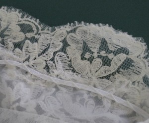 Neckline/shoulder stays hold the shoulder and sleeves in place with a wide deep neckline in the front and back. They are made from narrow braided elastic couched in place with catch stitch and fastened at each end.