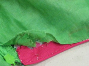 Lining fell stitched to neckline, armholes and along zipper tape.