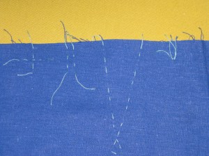 Marking by hand : L to R - crossed running stitches to mark dots; running stitch parallel to seam to mark notches; thread tracing to mark dart legs; tailor's tack to mark exact point