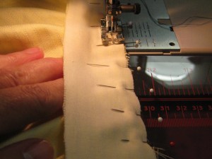 When stitching, keep fingers under stand and smooth fabric at right angles to seam line as you proceed around the neckline curve.