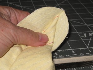 Roll the shirt tab edge tightly between the stand pieces.