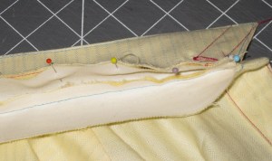 Collar flipped to inside neck edge and pinned with upper collar to inside of collar stand.