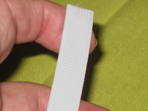 Smooth side lies against fabric; machine stitch in narrow lip on either side.