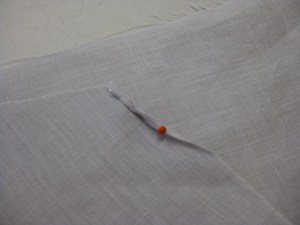 Pin the first couple of inches/centremetres in place and press the start of the hem.