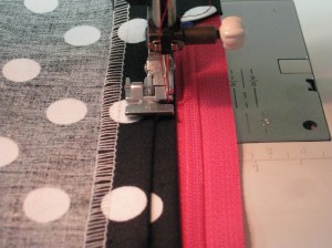 Stitch in place allowing space for zipper pull