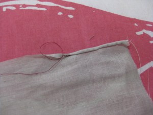 Carefully pull thread which will cause the hem to roll.