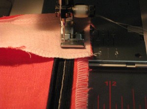 Attach zipper foot and stitch from the facing seam line along the inside of the seam allowance and close to the zipper teeth.