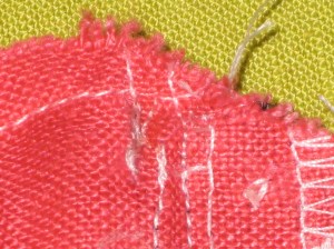 Stitching on the left is forming the pocket. Next stitching is attaching the zipper followed by stitching which attaches the facing and initial basting.