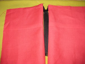 Place on a flat surface with right sides facing up and zipper in between. This makes it easier to determine where to sew.