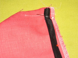 White mark indicates top of the plastic zipper stop. Teeth rest along the seam line with tape in the seam allowance.