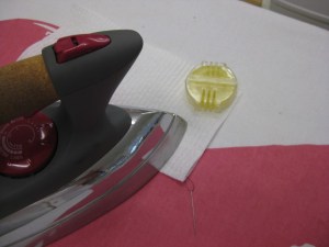 Run thread through wax and place between two sheets of paper towel; apply heat with iron and pull the thread through