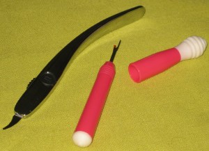 Gingher Retractable Seam Ripper and Unpicker with thread remover on top of lid